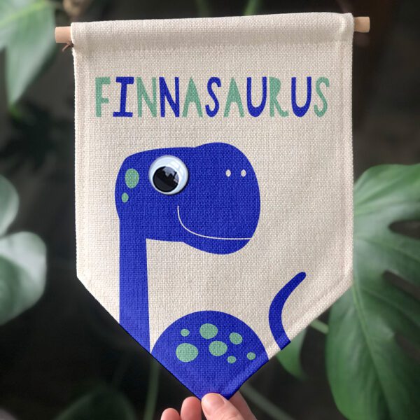 personalised dinosaur with googly eye on a gift flag with nameasaurus on it