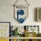 Dinosaur flag hung up above a shelf of books in kids nursery